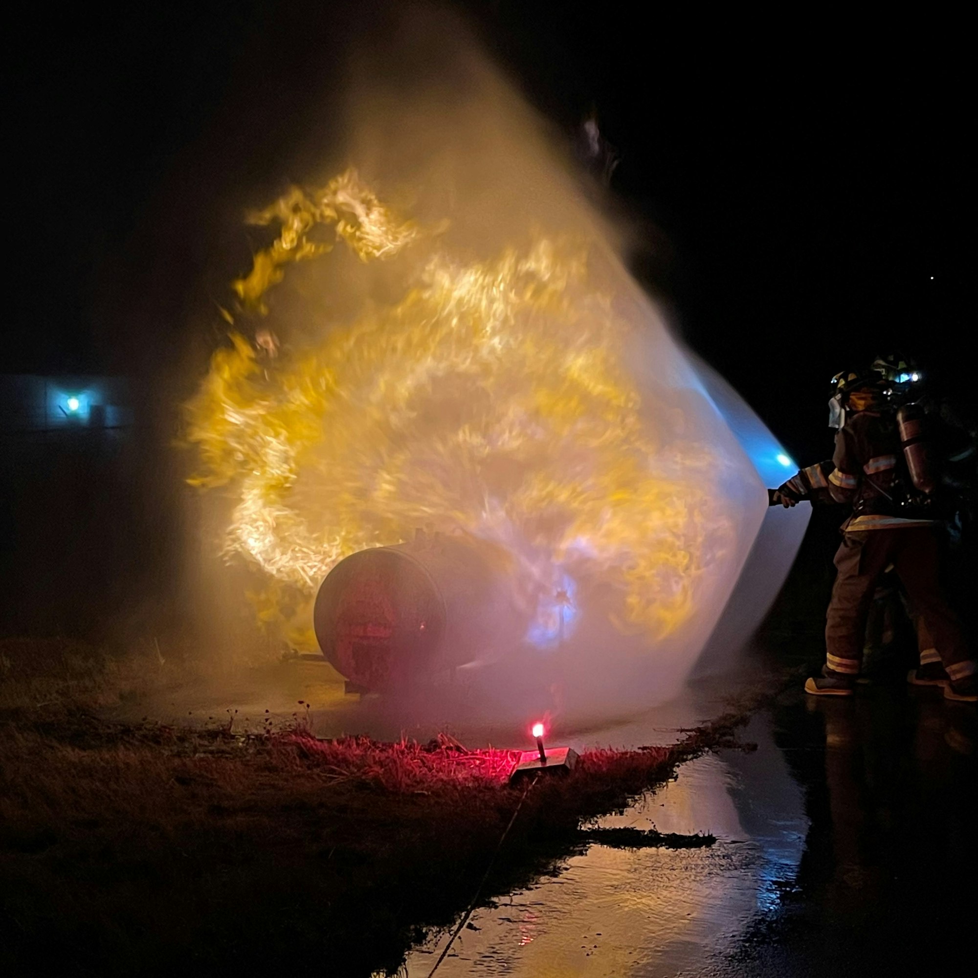 Firefighters, LPG flames, hose and water